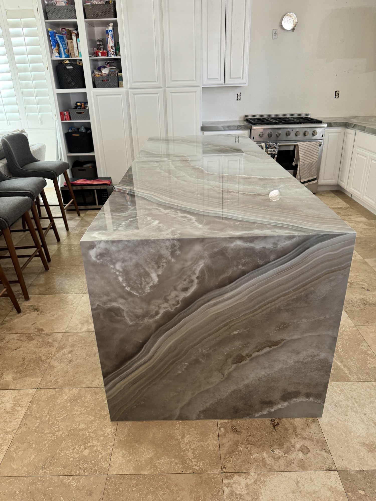 Bookmatched onyx waterfall island fabricated and installed by Rotech Granite