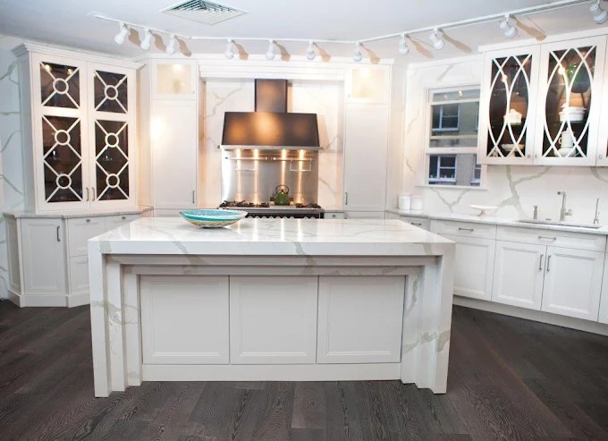 White kitchen with a Calacatta waterfall island and matching backsplash
